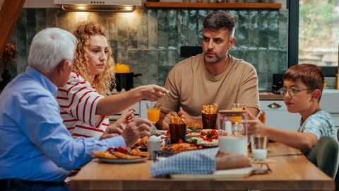 Family talking and eating dinner at a table